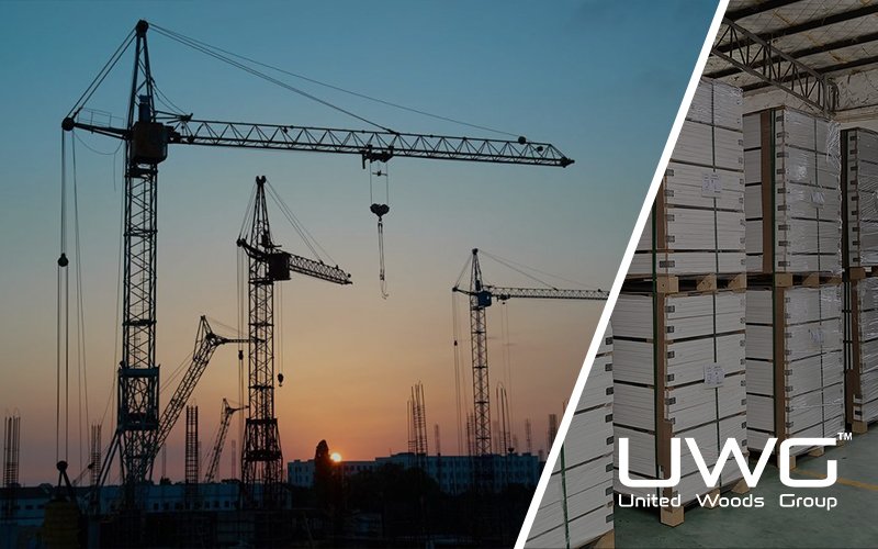Construction cranes silhouetted at sunset over a building site