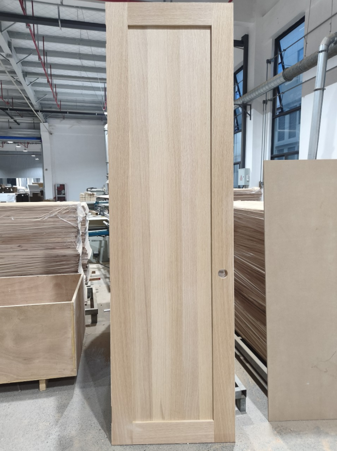 Light wood shaker-style interior door in factory setting