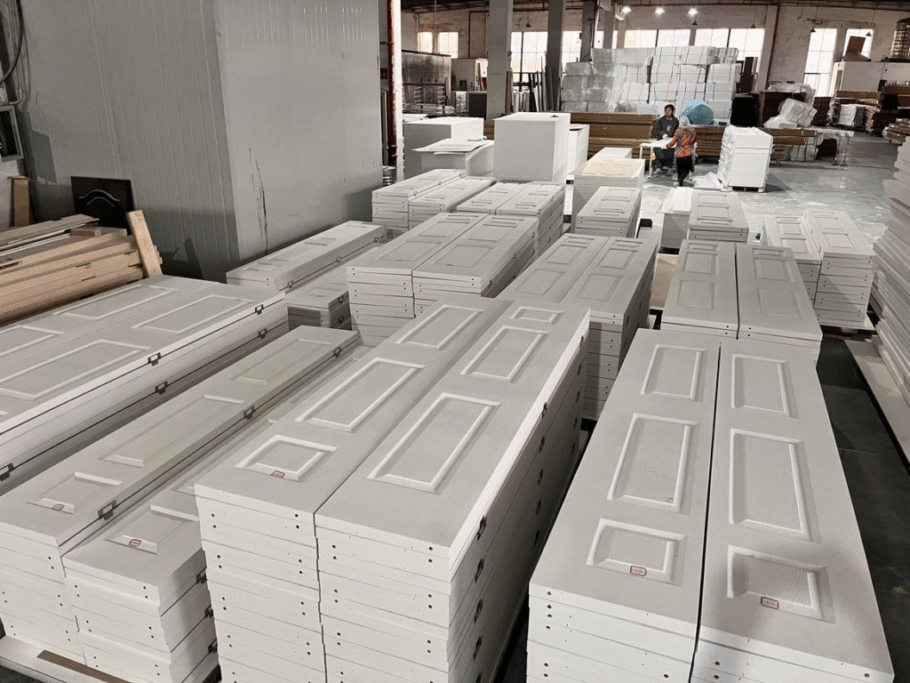 Custom white bifold door panels in bulk production at a door factory
